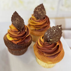 Cupcakes decorated with fall icing colors and chocolate leaf with gold flecks